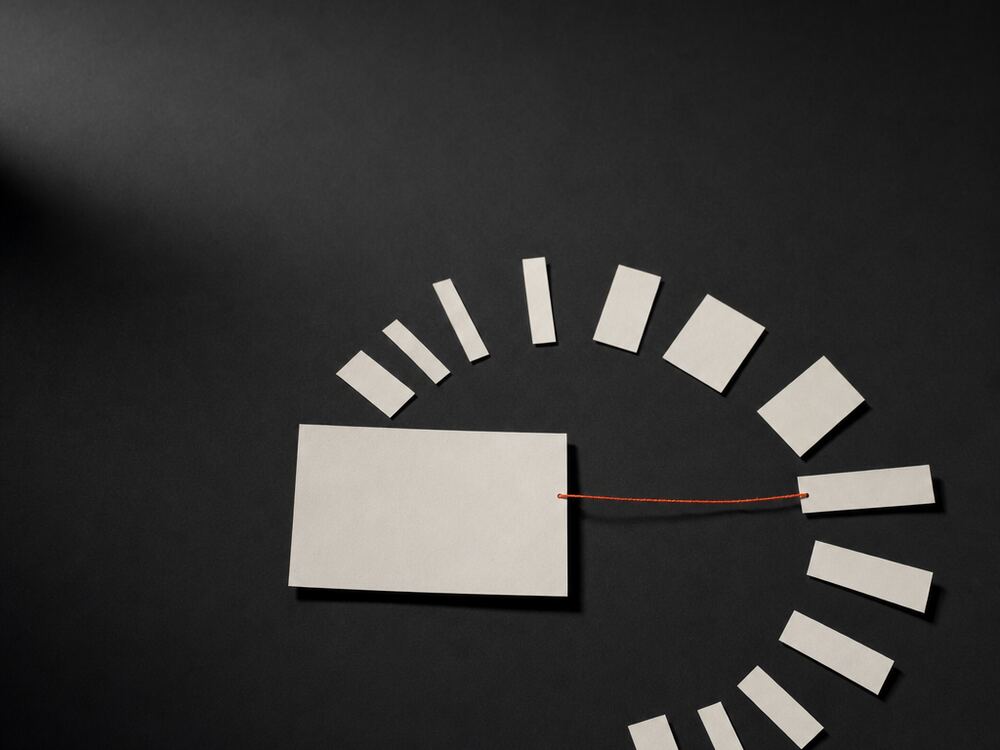 One large blank frame surrounded by twelve smaller frames fanned out, joined by a single orange thread.
